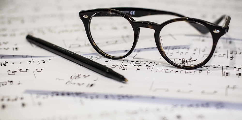 Glasses and pen on paper with musical notes