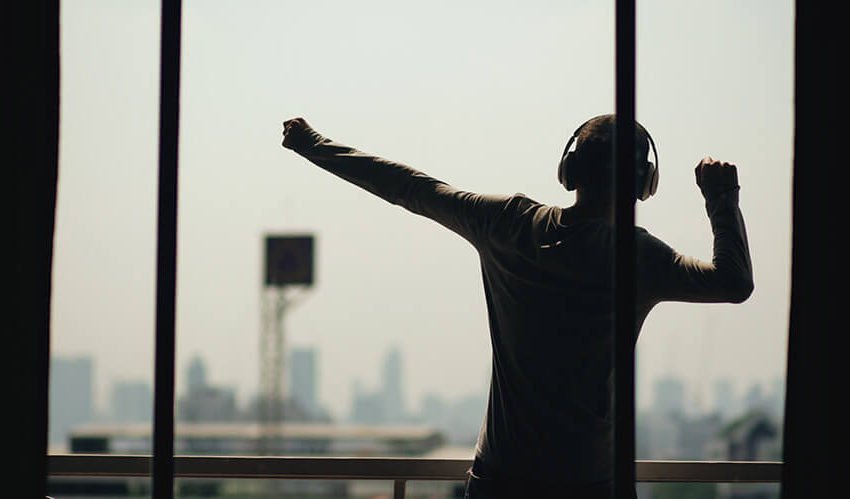 Man Dancing on Balcony Listening to Music on Headphones