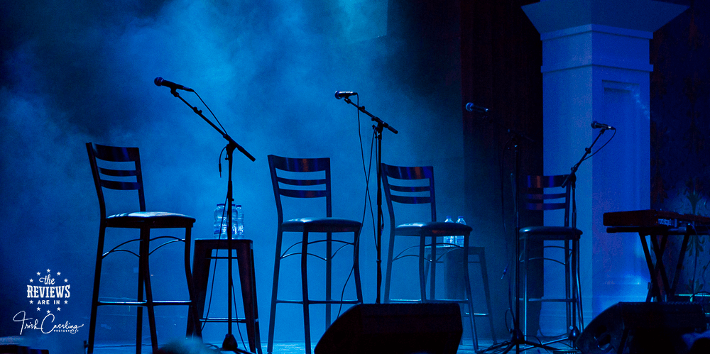 Empty tall chairs on a blue light stage